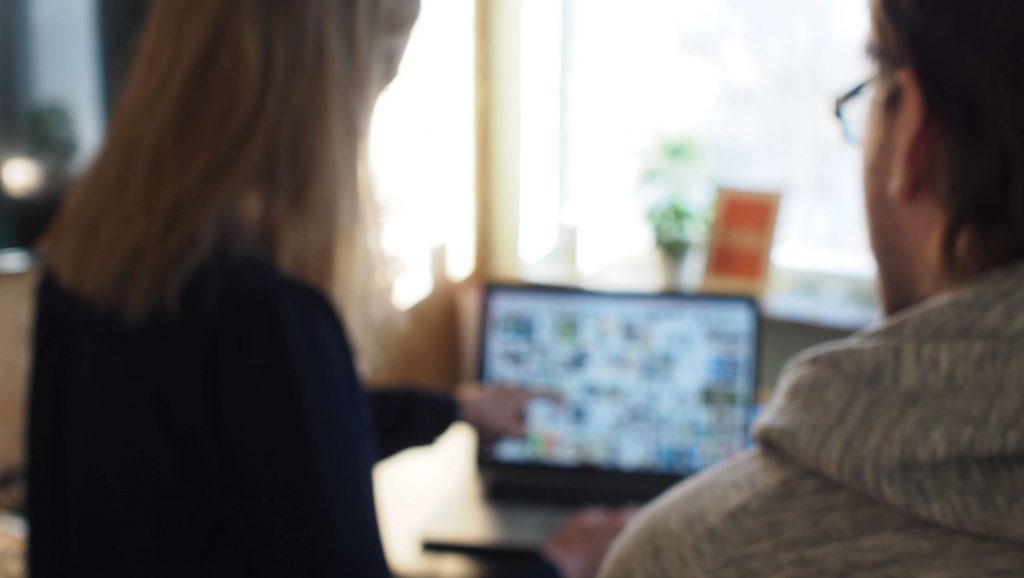 Ett par personer som tittar på en laptopskärm tillsammans.