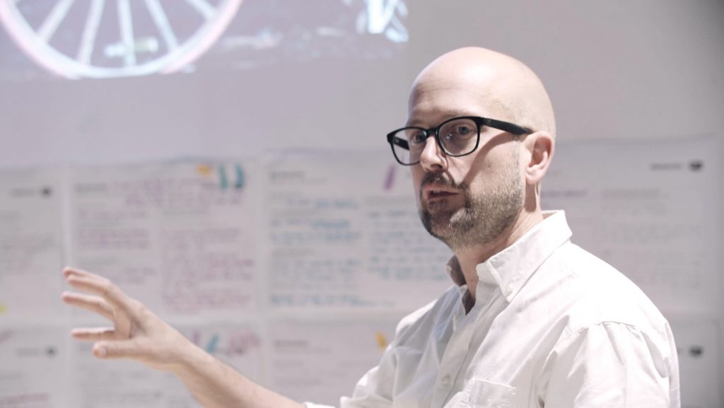 En person förklarar innehållet på en whiteboard.